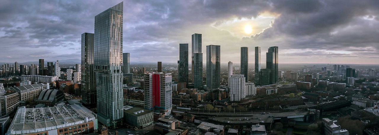 Aerial view of Manchester, UK, on a sunny day featuring Beetham Tower, modern skyscrapers, historic buildings, roads, railways, and construction cranes.; Shutterstock ID 2611444507; purchase_order: -; job: -; client: -; other: